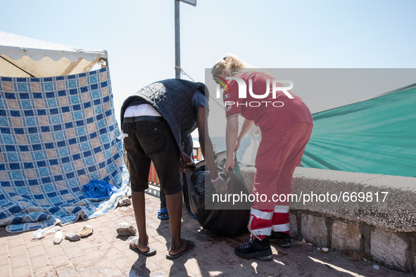 Migrants and volunteers keep the area clean, in Ventimiglia, on June 24, 2015. The situation of migrants camped in Ventimiglia has not chang...