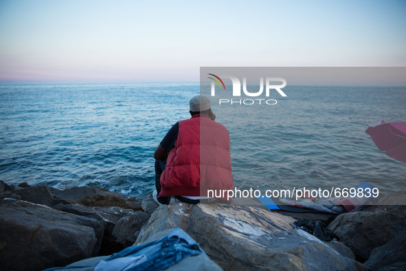 A migrant waits near the sea, in the city of Ventimiglia at the French-Italian border, on June 24, 2015. The situation of migrants camped in...