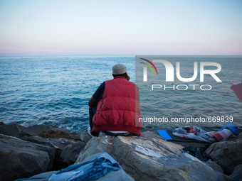 A migrant waits near the sea, in the city of Ventimiglia at the French-Italian border, on June 24, 2015. The situation of migrants camped in...