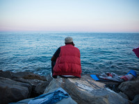 A migrant waits near the sea, in the city of Ventimiglia at the French-Italian border, on June 24, 2015. The situation of migrants camped in...