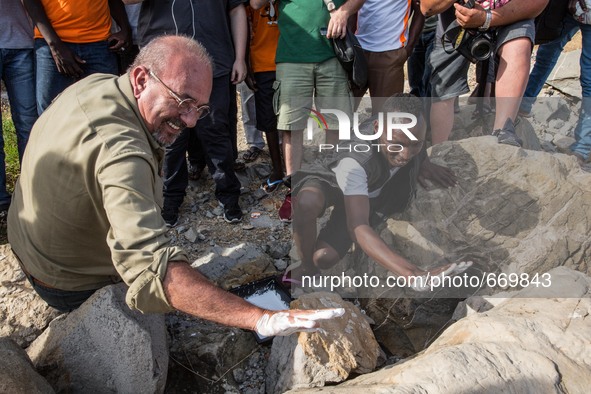 Vauro (L) famous political cartoonist, made an art installation on the rocks where migrants are, in Ventimiglia on June 25, 2015. The situat...