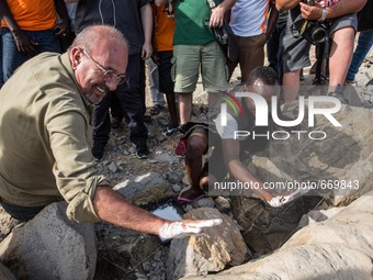 Vauro (L) famous political cartoonist, made an art installation on the rocks where migrants are, in Ventimiglia on June 25, 2015. The situat...