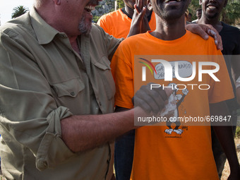 Vauro (L) famous political cartoonist, made an art installation on the rocks where migrants are, in Ventimiglia on June 25, 2015. The situat...