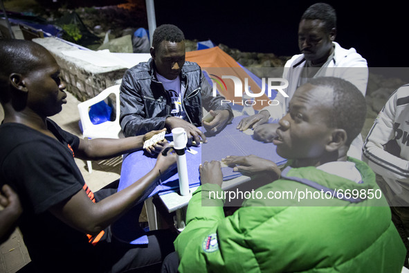 Migrants plays near the rocks where they sleep, in Ventimiglia, on June 27, 2015.  The situation of migrants camped in Ventimiglia has not c...