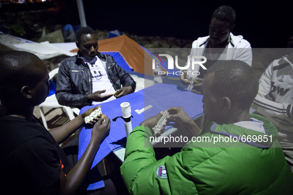 Migrants plays near the rocks where they sleep, in Ventimiglia, on June 27, 2015.  The situation of migrants camped in Ventimiglia has not c...