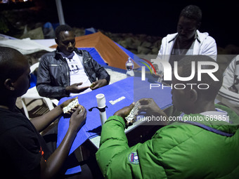 Migrants plays near the rocks where they sleep, in Ventimiglia, on June 27, 2015.  The situation of migrants camped in Ventimiglia has not c...