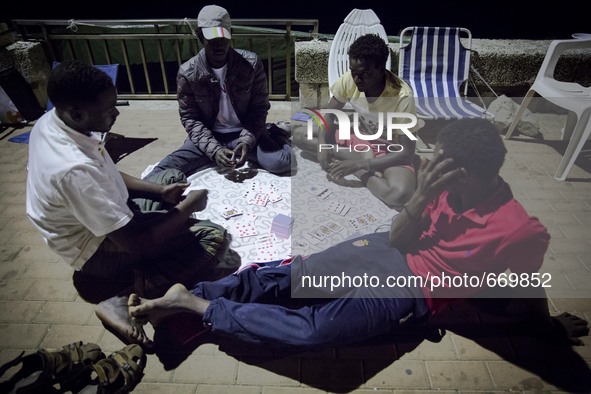 Migrants plays near the rocks where they sleep, in Ventimiglia, on June 27, 2015.  The situation of migrants camped in Ventimiglia has not c...