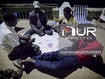 Migrants plays near the rocks where they sleep, in Ventimiglia, on June 27, 2015.  The situation of migrants camped in Ventimiglia has not c...