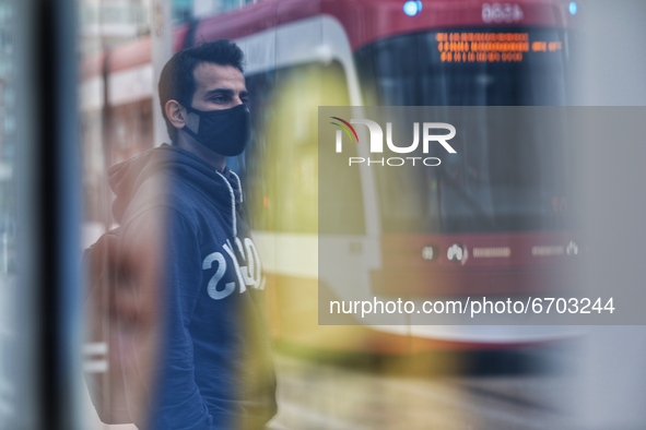 A man wearing a protective face mask waits at a bus stop in Downtown Toronto in Toronto, Canada on May 10, 2021. Ontario reported 2,716 new...