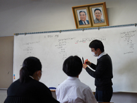 Pictures of Kim Il Sung and Kim Jong Il hang on the wall as a teacher conducts a math lecture at Hiroshima Korean School on May 9, 2021 in H...