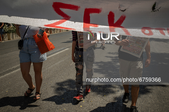 A student is standing behind a banner in Athens, Greece, on May 27, 2021. 