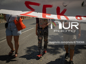 A student is standing behind a banner in Athens, Greece, on May 27, 2021. (