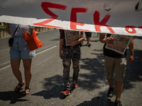 A student is standing behind a banner in Athens, Greece, on May 27, 2021. (