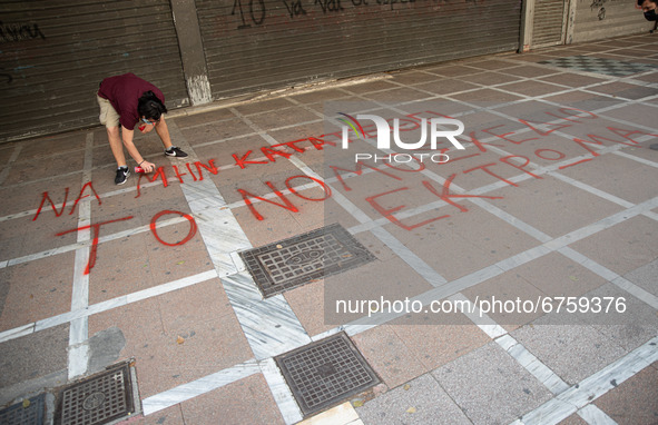  A student is spray painting a slogan at the street in Athens, Greece, on May 27, 2021. 