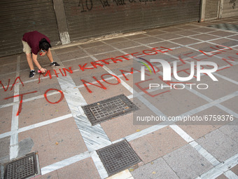  A student is spray painting a slogan at the street in Athens, Greece, on May 27, 2021. (