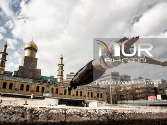 Parkour performer in Ekbatan and the mosque in the background. (