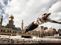 Parkour performer in Ekbatan and the mosque in the background. (