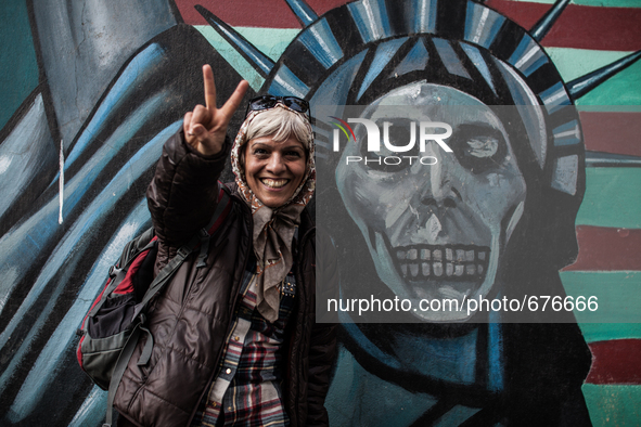 Symbolic portrait of woman that shows sign of peace infront of the old closed US embassy in Tehran as a symbol that most of people doesn't h...