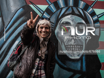 Symbolic portrait of woman that shows sign of peace infront of the old closed US embassy in Tehran as a symbol that most of people doesn't h...