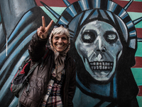 Symbolic portrait of woman that shows sign of peace infront of the old closed US embassy in Tehran as a symbol that most of people doesn't h...