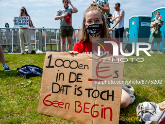 A student is sitting while holding a placard against the student loan system, during the Nationwide student strike, organized in The Hague,...