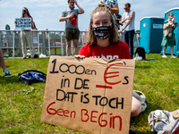 A student is sitting while holding a placard against the student loan system, during the Nationwide student strike, organized in The Hague,...