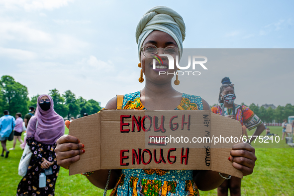 A Black student is holding a placard that says in Dutch enough is enough, during the Nationwide student strike, organized in The Hague, Neth...