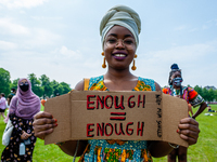 A Black student is holding a placard that says in Dutch enough is enough, during the Nationwide student strike, organized in The Hague, Neth...