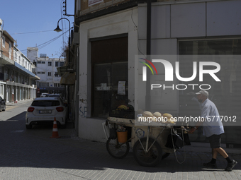 A Turkish Cypriot man pulls a cart of melons for sale down a street in Turkish-occupied territory in the northern part of the divided capita...