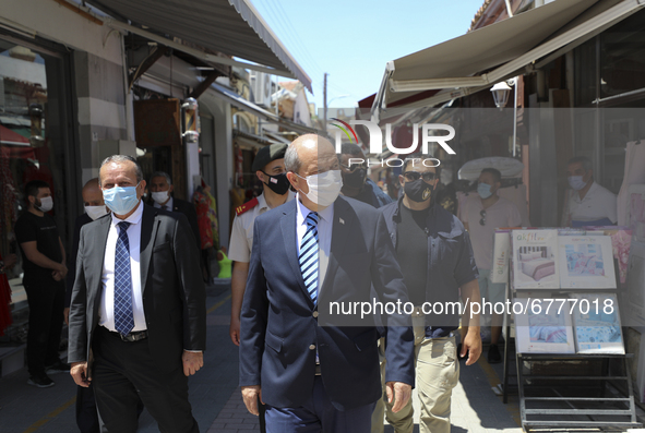 Turkish Cypriot leader Ersin Tatar, center, drives along a shopping street in Turkish-occupied territory in the northern part of the divided...