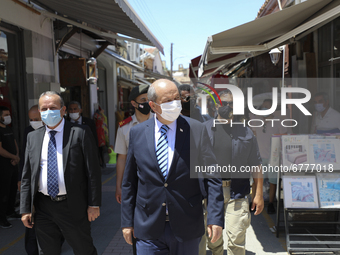 Turkish Cypriot leader Ersin Tatar, center, drives along a shopping street in Turkish-occupied territory in the northern part of the divided...