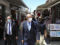 Turkish Cypriot leader Ersin Tatar, center, drives along a shopping street in Turkish-occupied territory in the northern part of the divided...