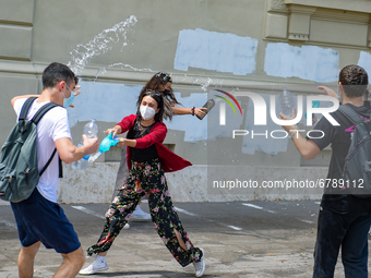 Last day of lessons of a difficult school year, smiles hidden among the masks and water balloons to celebrate the last day of school, with t...