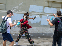 Last day of lessons of a difficult school year, smiles hidden among the masks and water balloons to celebrate the last day of school, with t...