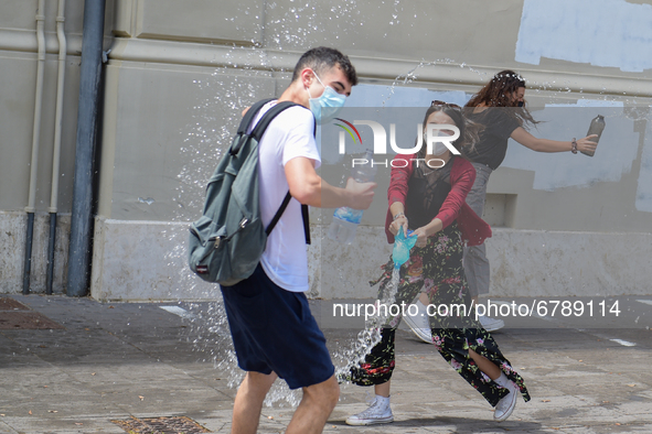 Last day of lessons of a difficult school year, smiles hidden among the masks and water balloons to celebrate the last day of school, with t...