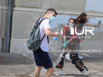 Last day of lessons of a difficult school year, smiles hidden among the masks and water balloons to celebrate the last day of school, with t...