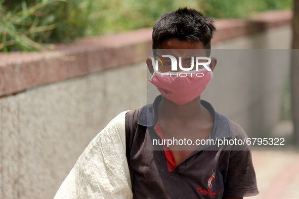 Rahul, 8, a ragpicker looks for recyclable materials specially plastic bottles strewn around roads to support his family, ahead of the World...