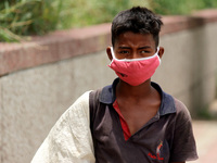 Rahul, 8, a ragpicker looks for recyclable materials specially plastic bottles strewn around roads to support his family, ahead of the World...