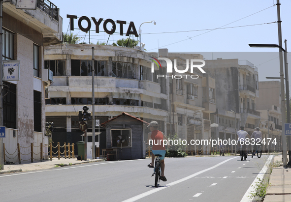 A boy rides a bicycle through an area fenced in by the Turkish military since 1974 in the abandoned coastal area of Varosha, a suburb of the...