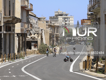 Tourists cycle through an area fenced in by the Turkish military since 1974 in the abandoned coastal area of Varosha, a suburb of the city o...