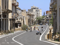 Tourists cycle through an area fenced in by the Turkish military since 1974 in the abandoned coastal area of Varosha, a suburb of the city o...