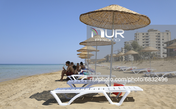 Tourists relax on a beach fenced by the Turkish military since 1974 in the abandoned coastal area of Varosha, a suburb of the city of Famagu...