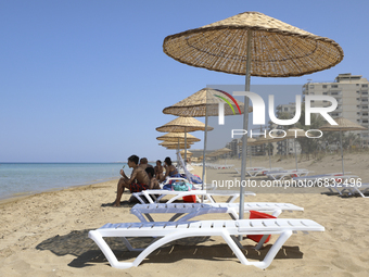 Tourists relax on a beach fenced by the Turkish military since 1974 in the abandoned coastal area of Varosha, a suburb of the city of Famagu...