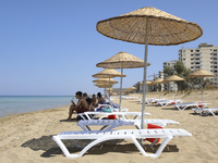 Tourists relax on a beach fenced by the Turkish military since 1974 in the abandoned coastal area of Varosha, a suburb of the city of Famagu...