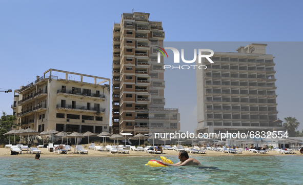 A man swims in the Mediterranean Sea, which has been fenced in by the Turkish military since 1974, in the abandoned coastal area of Varosha,...