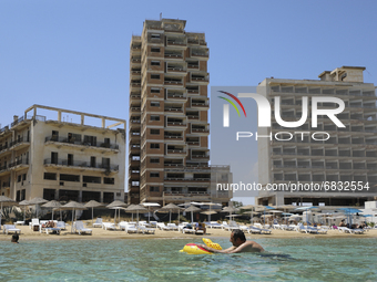 A man swims in the Mediterranean Sea, which has been fenced in by the Turkish military since 1974, in the abandoned coastal area of Varosha,...