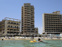 A man swims in the Mediterranean Sea, which has been fenced in by the Turkish military since 1974, in the abandoned coastal area of Varosha,...