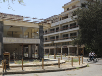 Tourists cycle past an abandoned Bank of Cyprus building, fenced off by the Turkish military since 1974, in the abandoned coastal area of Va...