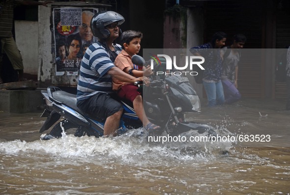 Indian school boy returning home   along  the waterlogged street due to heavy rain in Kolkata, India on  Friday, July 10, 2015. 