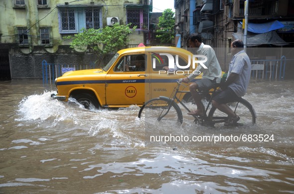 Indian taxi driver and the other  people transports  passengers  in  the waterlogged street due to heavy rain in Kolkata, India on  Friday,...